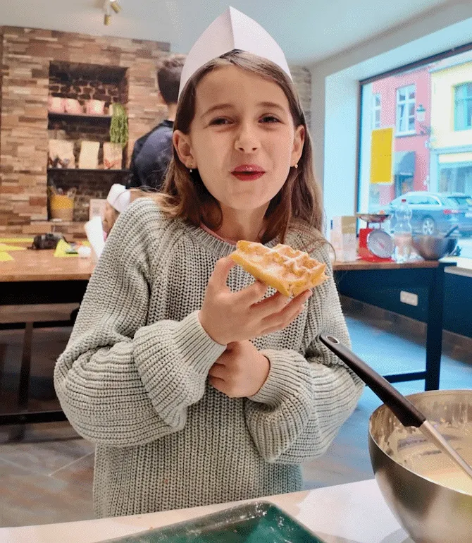 Girl eating a freshly baked Belgian waffle